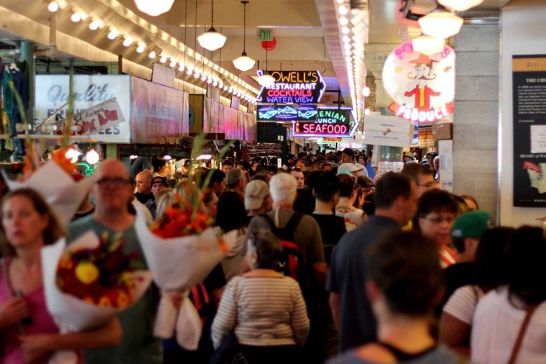 people-mall-resize A crowd of shoppers in a gaudy mall shows the pathology of excessive consumption, which has a bad effect on the physical environment